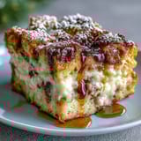 Layers of cinnamon-vanilla French bread, ham, turkey, and melted Swiss cheese in a slice.