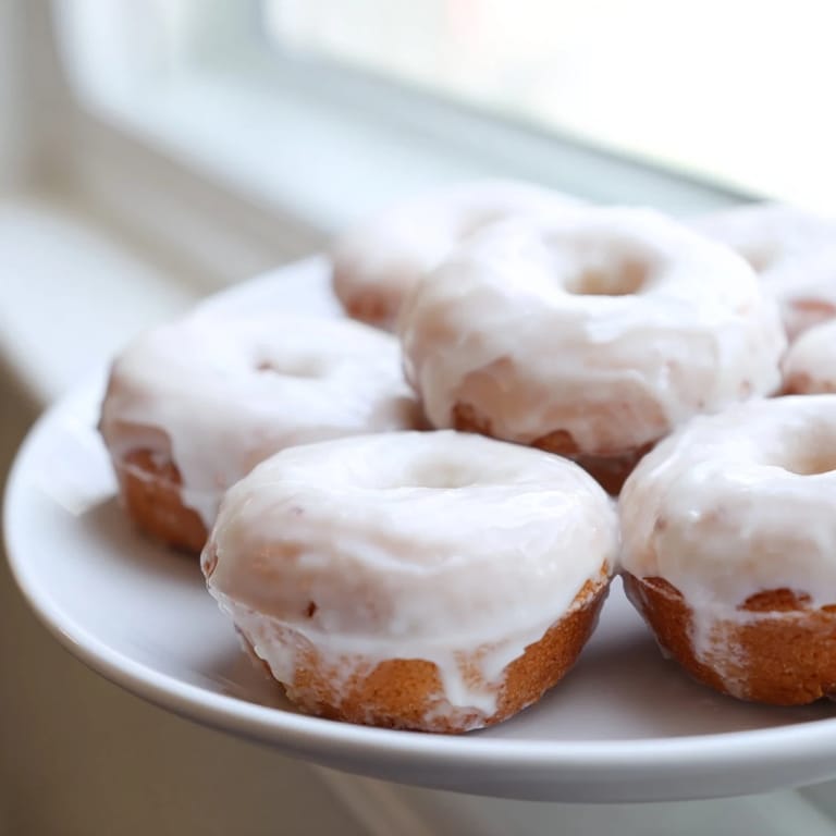 Soft, cakey muffin tin donuts, ready to eat, creating the classic bakery donut experience at home.