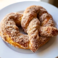 Warm, golden Cinnamon Sugar Pretzels, ready to eat, coated in a sweet, crunchy cinnamon-sugar blend.
