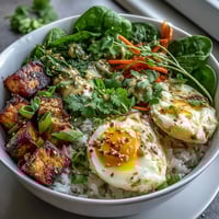 Vibrant Tofu Jammy Egg Breakfast Bowl with seasoned tofu, soft-boiled eggs, and fresh greens on steamed rice.  