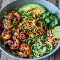 Grilled shrimp Asian noodle bowl with smoky shrimp, sesame egg noodles, and fresh avocado, cucumber, and crunchy peanuts.